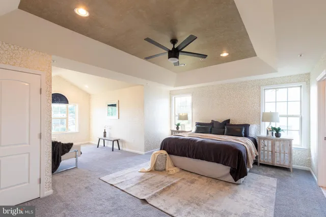 a spacious bedroom with a large bed and a chandelier