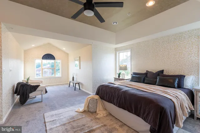 a spacious bedroom with a bed and a large window