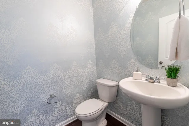 a bathroom with a sink toilet and a mirror