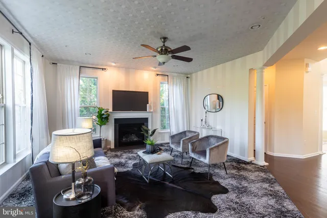a living room with furniture a fireplace and a large window