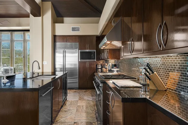 a kitchen with granite countertop a sink stainless steel appliances and cabinets