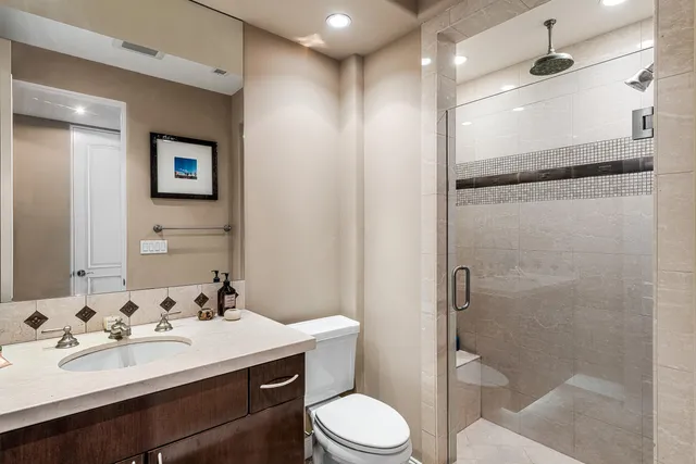 a bathroom with a sink toilet vanity and shower