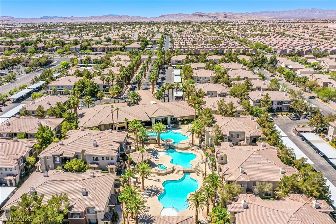 9050 West Warm Springs Road, Unit 1011 Las Vegas, NV 89148 - Photo 32 of 32 An aerial perspective reveals a vibrant community with inviting pools and mature palm trees.
