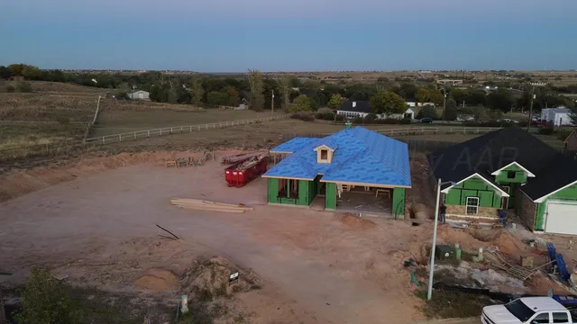 a aerial view of a house with a yard wooden table and chairs