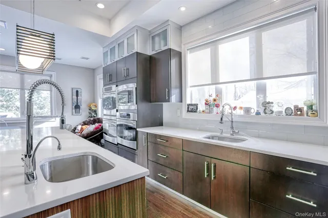 a kitchen with stainless steel appliances cabinets a sink and a large window