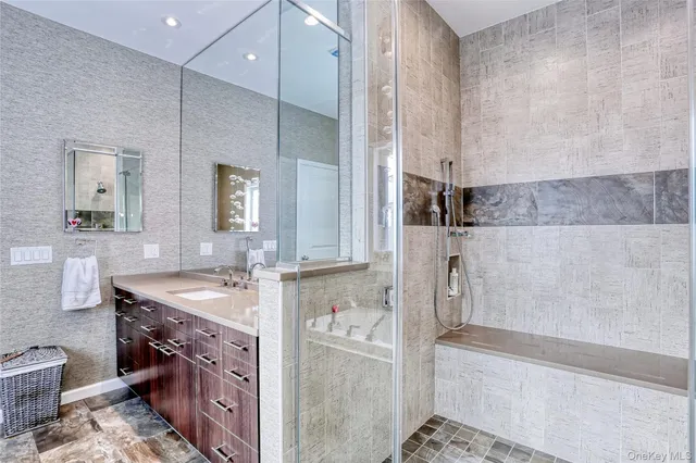 a bathroom with a granite countertop sink a mirror and a bathtub