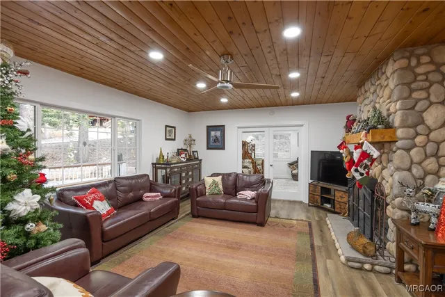 a living room with furniture a flat screen tv and a wooden floor