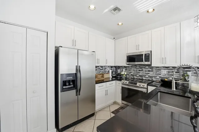 a kitchen with stainless steel appliances granite countertop a refrigerator and microwave