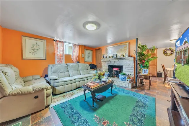 a living room with furniture a fireplace and a large window