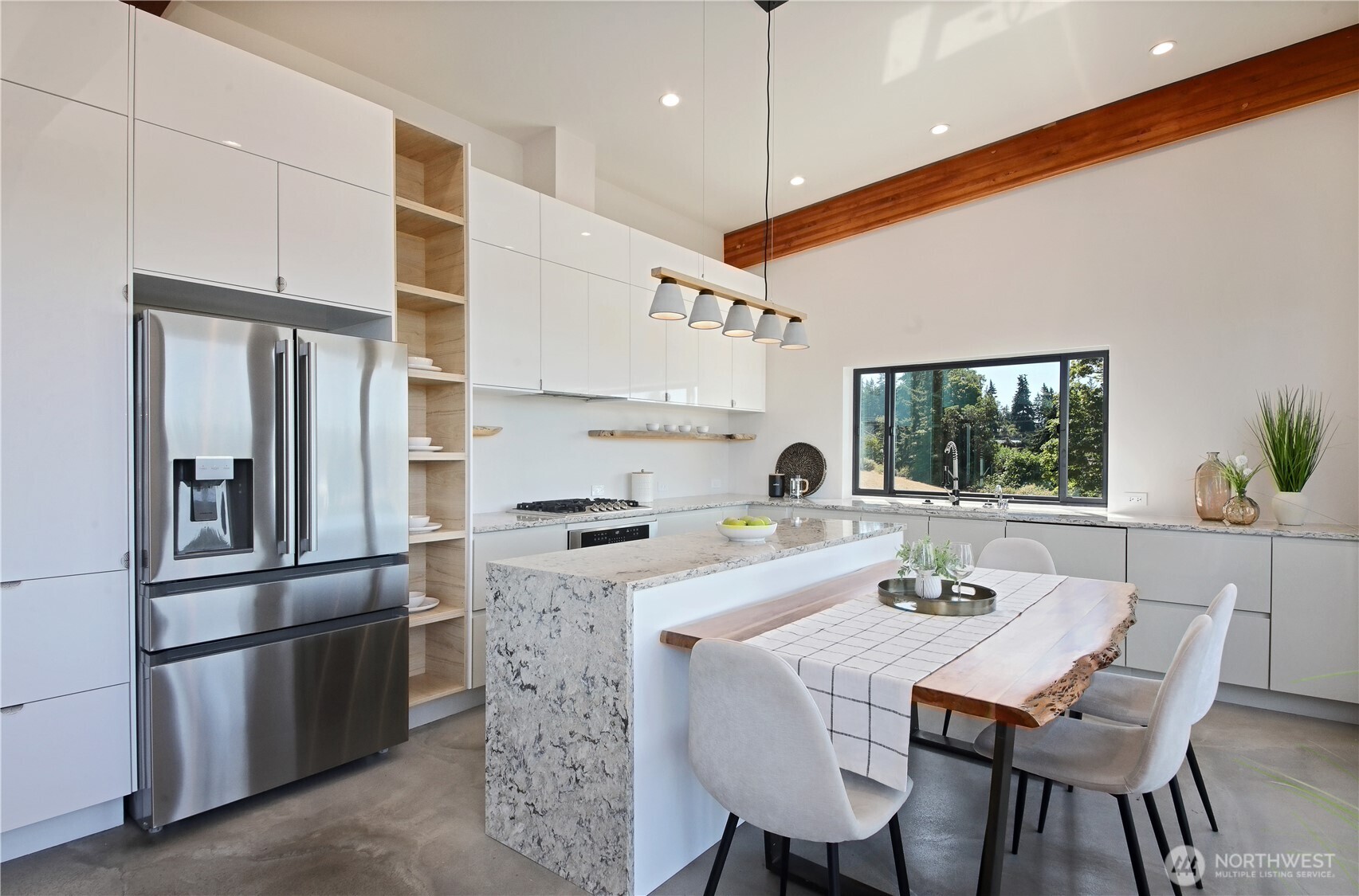 5453 Harborside Lane Freeland, WA 98249 - Photo 10 of 25 a kitchen with stainless steel appliances granite countertop a stove a refrigerator a kitchen island with chairs and white cabinets