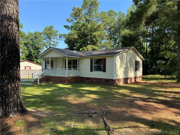 a view of a house with a yard patio and tree