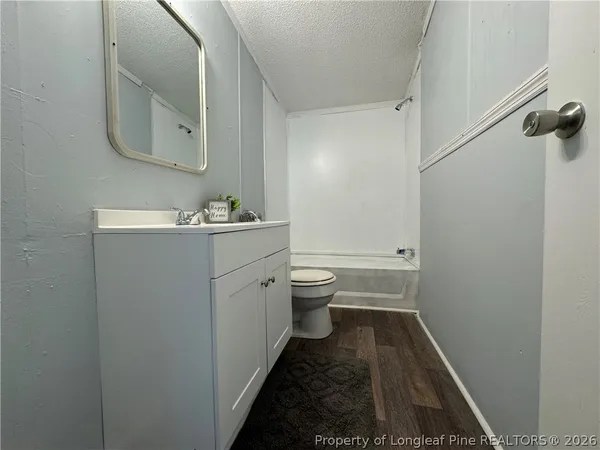 a bathroom with a sink and mirror with toilet