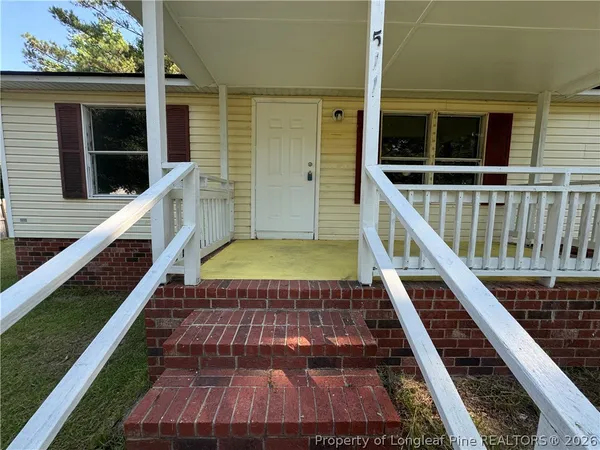 a view of a balcony with wooden floor and fence