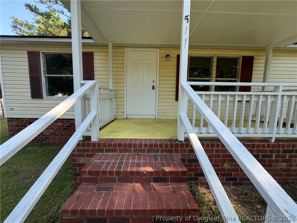 511 Inverary Drive Raeford, NC 28376 - Photo 3 of 32 a view of a balcony with wooden floor and fence
