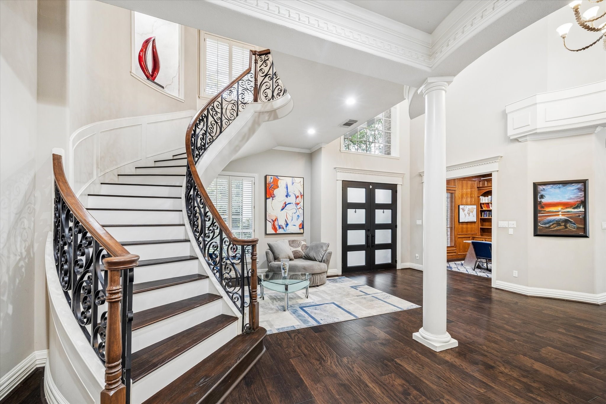 35 North Regent Oak Spring, TX 77381 - Photo 5 of 43 An awe-inspiring two-story foyer welcomes you with a graceful curved staircase featuring intricate wrought-iron detailing and rich wood accents. Framed by soaring ceilings, stately columns, and exquisite architectural millwork, this grand entry creates an immediate sense of elegance and scale. Bathed in natural light, the space serves as a sophisticated introduction to this distinguished custom estate.