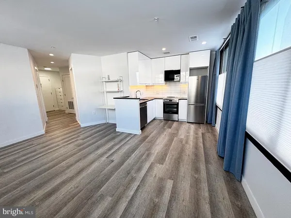 a kitchen with stainless steel appliances a white stove top oven and a refrigerator