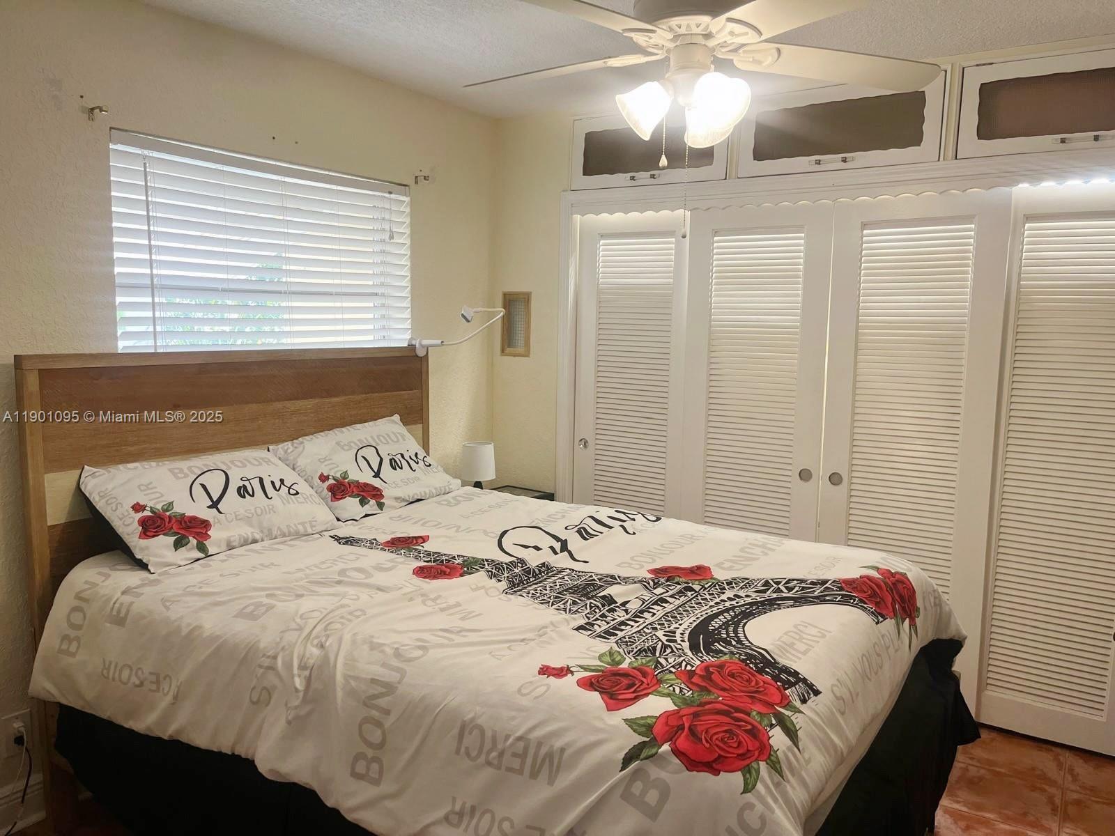 4913 Northwest 47th Avenue, Unit 4913 Tamarac, FL 33319 - Photo 5 of 7 a bedroom with a bed and a chandelier