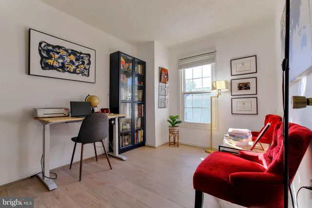 a living room with furniture a desk and chair with wooden floor