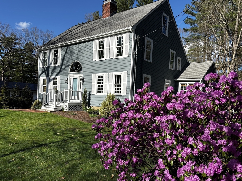 142 Baker Street Walpole, MA 02081 - Photo 2 of 42 a front view of a house with a lot of flowers and yard