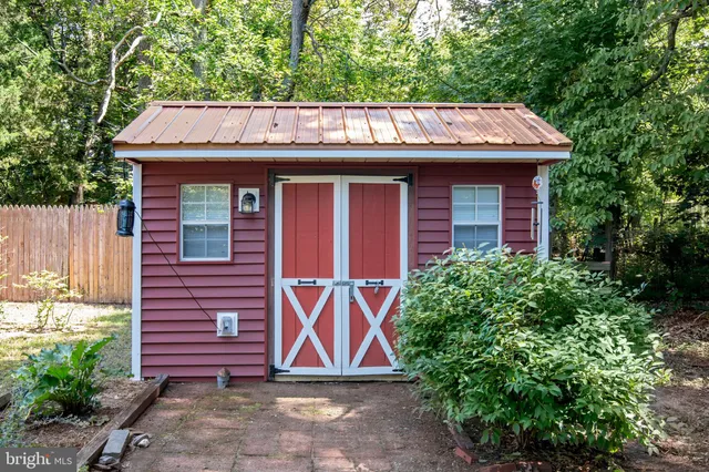 a view of brick house with large windows and a barn