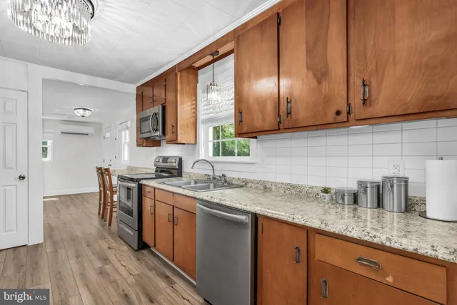 a kitchen with stainless steel appliances granite countertop wooden cabinets a sink and dishwasher