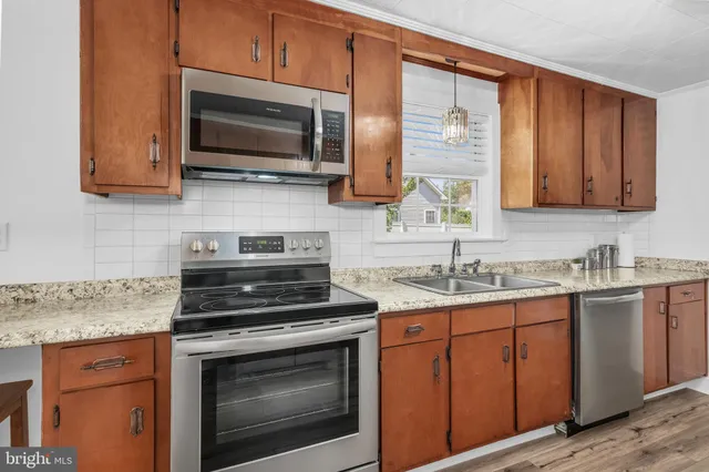 a kitchen with stainless steel appliances granite countertop a sink stove and microwave