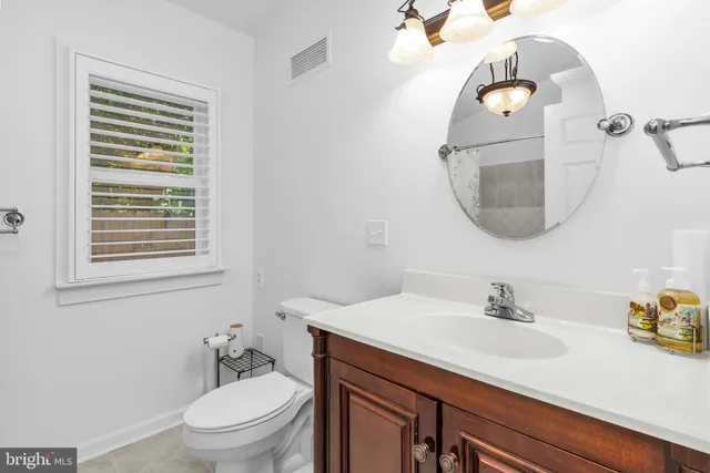 a bathroom with a sink a toilet and mirror