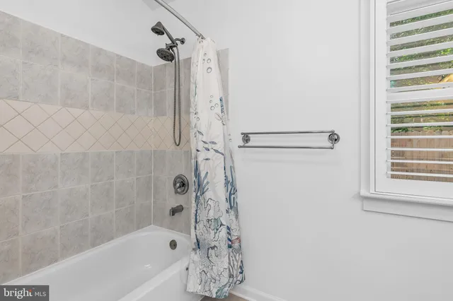 a bathroom with a bathtub a shower and a shower