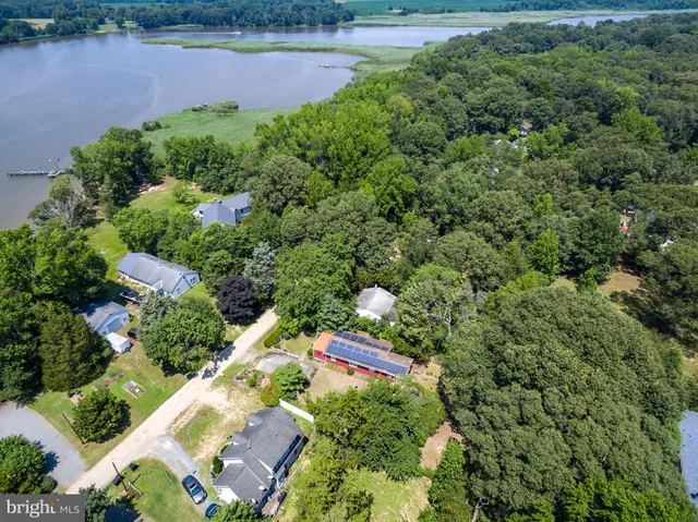 an aerial view of a house with a yard and lake view