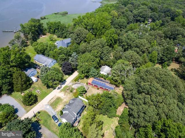 an aerial view of a house with a yard and green space