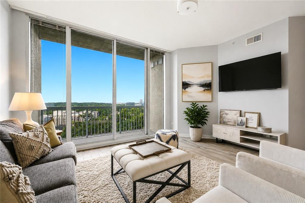 3300 Windy Ridge Parkway Southeast, Unit 1112 Atlanta, GA 30339 - Photo 12 of 43 a living room with furniture a flat screen tv and a large window