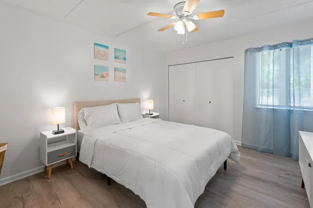 a bedroom with a bed wooden floor and window