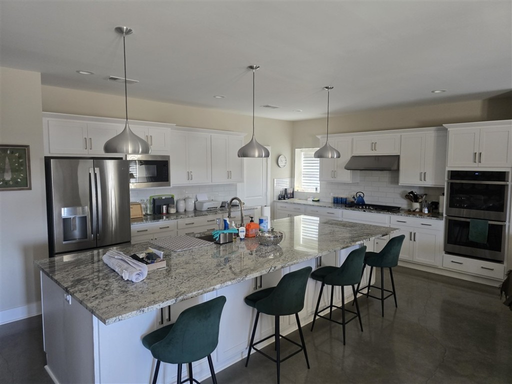 1684 County Road 2234 Lampasas, TX 76550 - Photo 19 of 35 a kitchen with stainless steel appliances granite countertop a kitchen island a stove a table and chairs