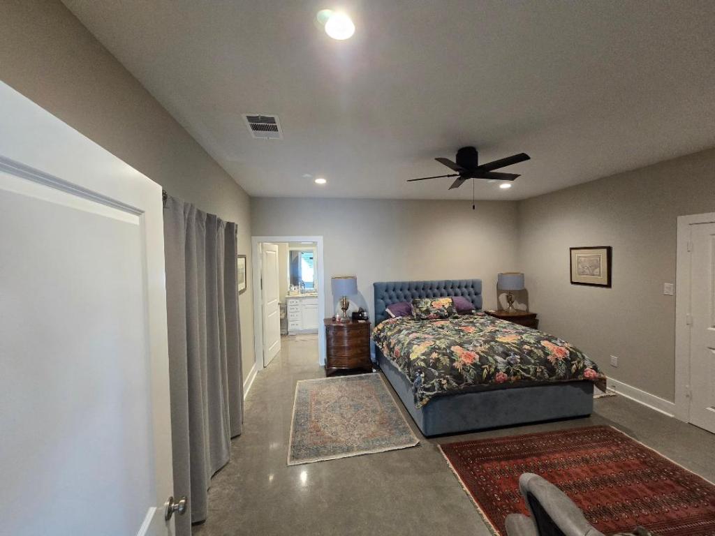 1684 County Road 2234 Lampasas, TX 76550 - Photo 27 of 35 a bedroom with a large bed and a chandelier