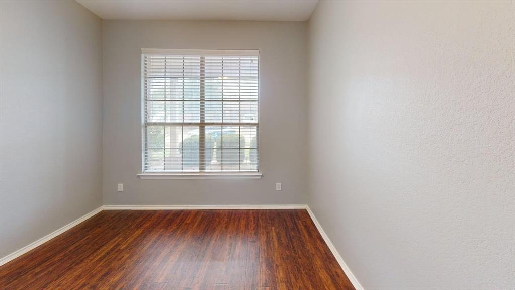 14308 Polo Ranch Street Fort Worth, TX 76052 - Photo 12 of 19 Spacious room featuring wood-finish flooring, light grey walls, white baseboards, and a large window with white blinds