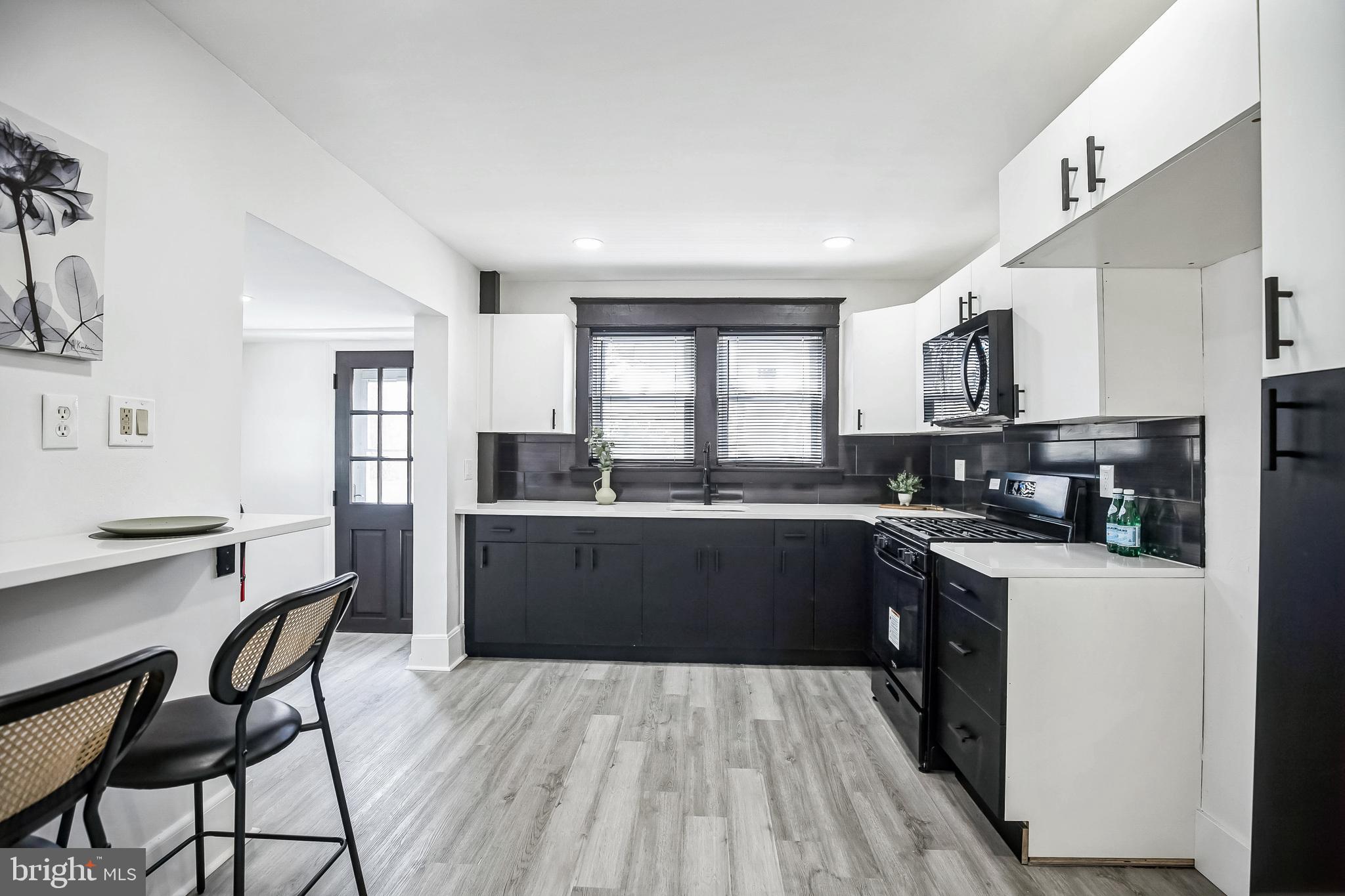 24 Cuthbert Road Cinnaminson, NJ 08077 - Photo 13 of 30 a kitchen with stainless steel appliances kitchen island wooden floors and white cabinets