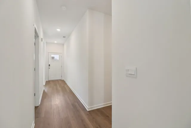 a view of a hallway with wooden floor
