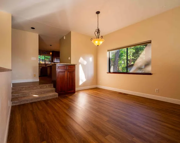 a view of a kitchen with stainless steel appliances wooden floor and a large window