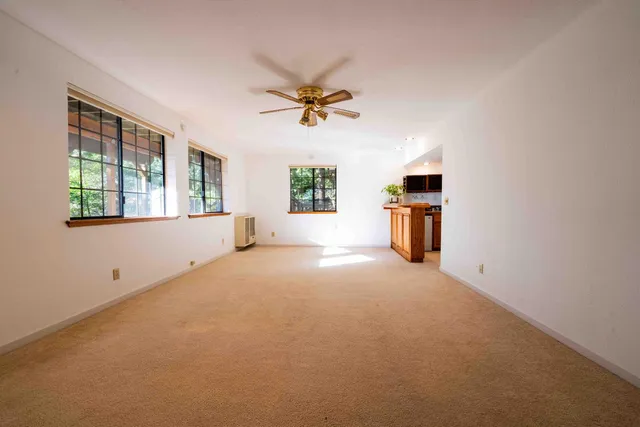 an empty room with windows and ceiling fan view