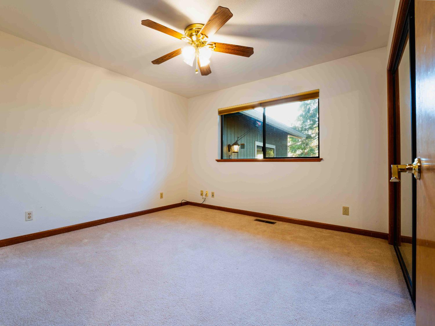 11419 Sunset Place Grass Valley, CA 95949 - Photo 34 of 47 an empty room with a window and a fan
