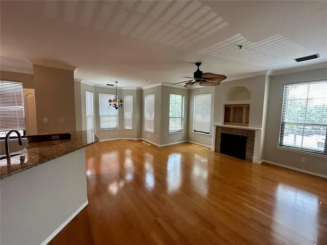 a view of a big room with wooden floor and a kitchen