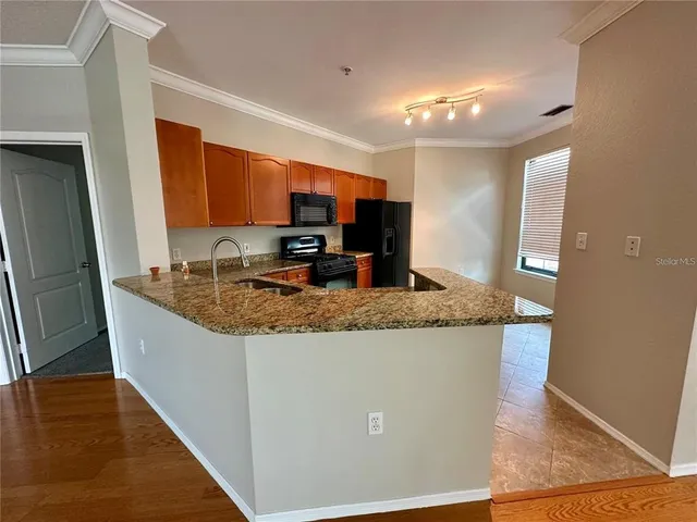 a view of kitchen with granite countertop window and wooden floor