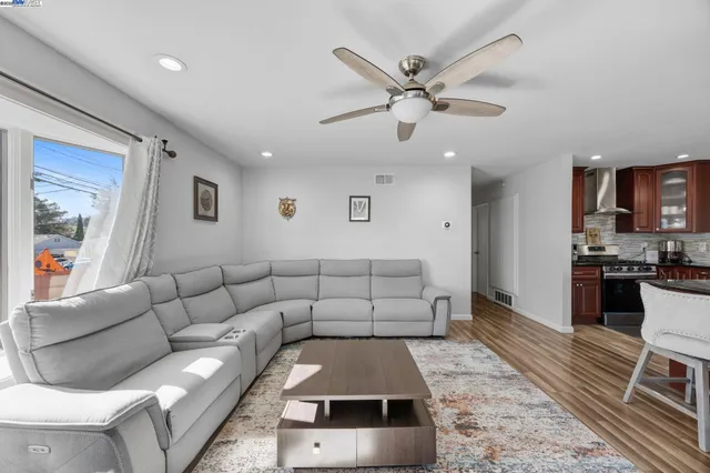 a living room with furniture and kitchen view