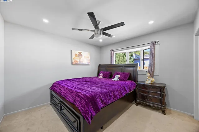 a bedroom with a bed and a ceiling fan