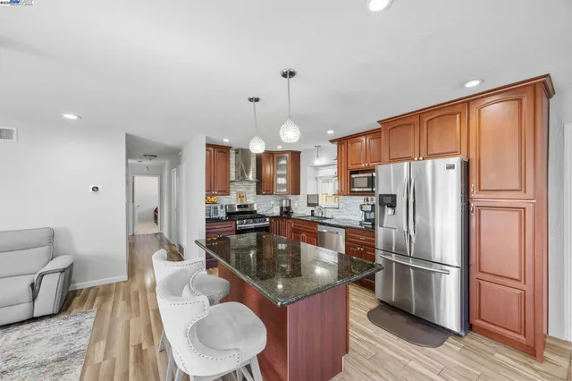 a kitchen with a refrigerator a sink and chairs