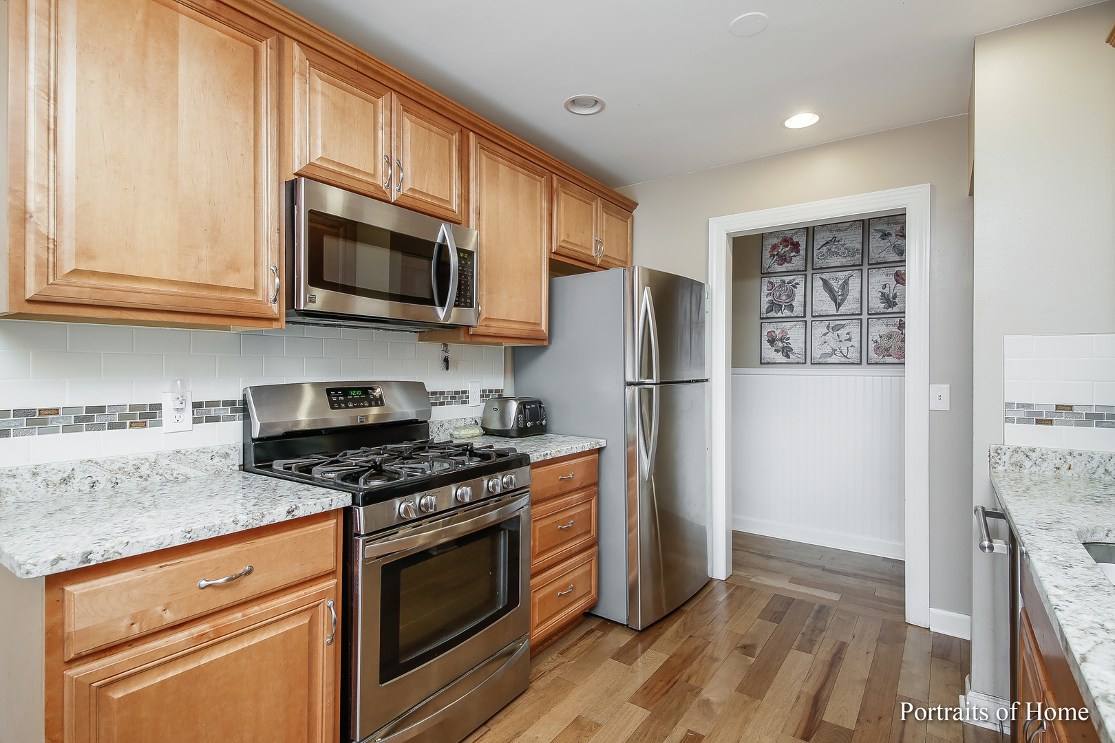 6 Shermead Road Montgomery, IL 60538 - Photo 23 of 25 a kitchen with stainless steel appliances granite countertop a refrigerator stove and microwave with wooden floor