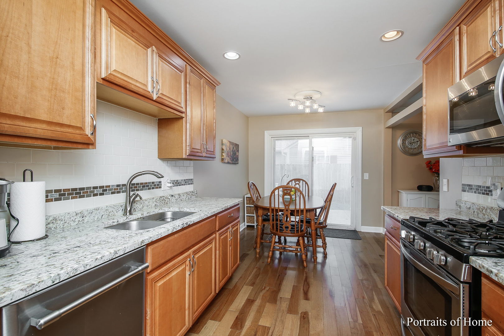 6 Shermead Road Montgomery, IL 60538 - Photo 7 of 25 a kitchen with granite countertop a sink a stove top oven a dining table and chairs