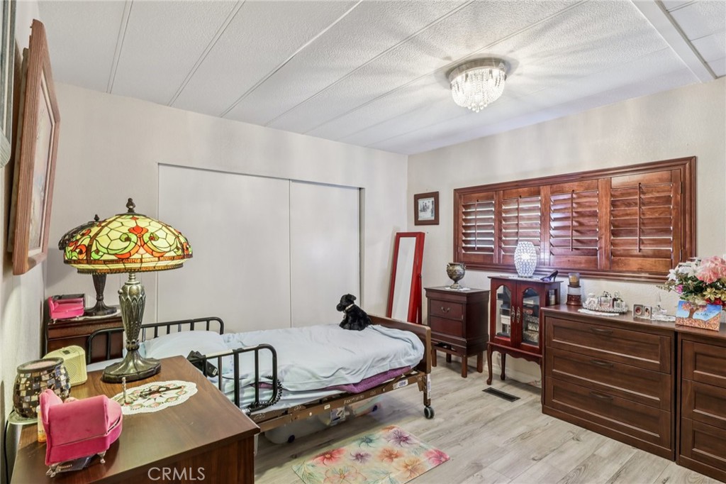 3700 Buchanan Street, Unit 28 Riverside, CA 92503 - Photo 23 of 35 a bedroom with a bed and a chandelier