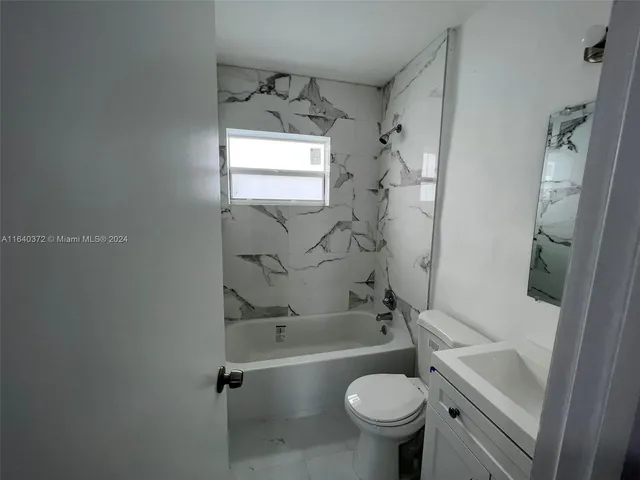 a bathroom with a sink toilet tub and shower