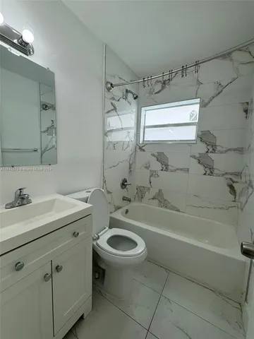 a bathroom with a granite countertop sink a toilet and shower